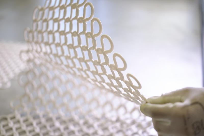 Collaborateur manipulant un matériau Flexiprint développé par Blachere Illumination pour concevoir des décors lumineux innovants et durables.