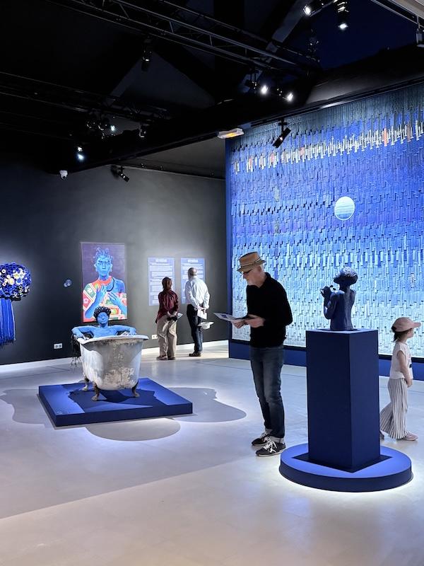 Visiteurs parcourant l'exposition AFROBLUE à la Fondation Blachère et découvrant les œuvres inspirées par les nuances du bleu.